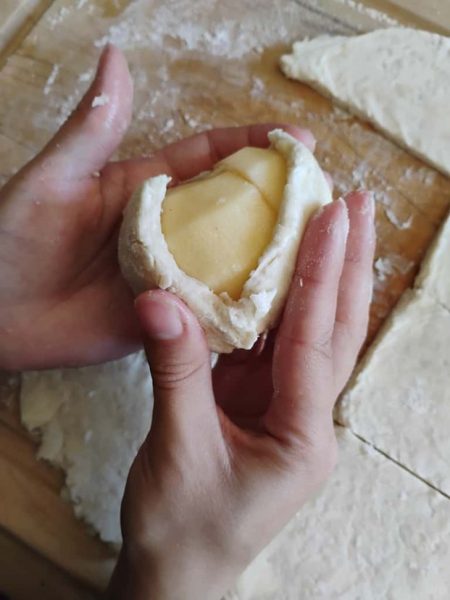 Apple being wrapped in dough