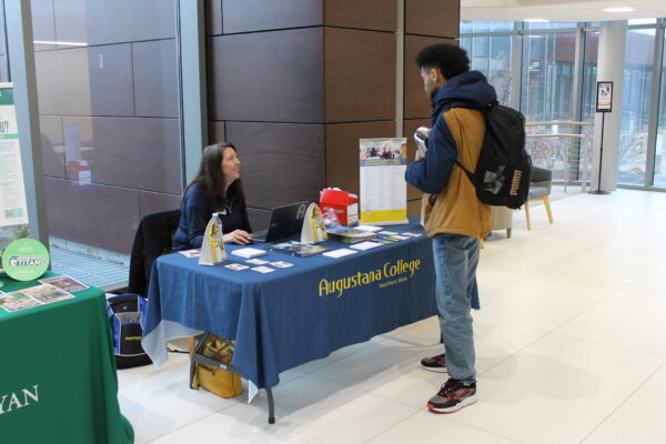 A person standing at a table with a blue tablecloth