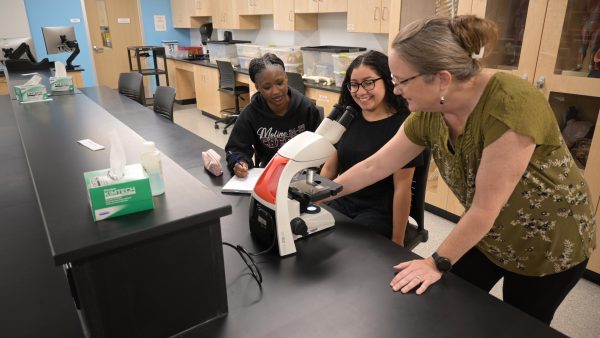 Students learning with a microscope.
