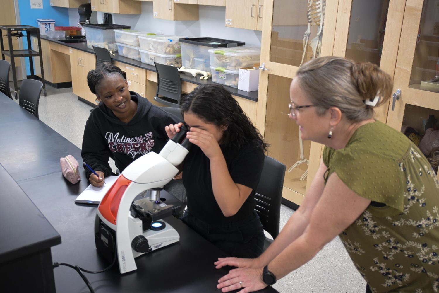Students observing through a microscope.