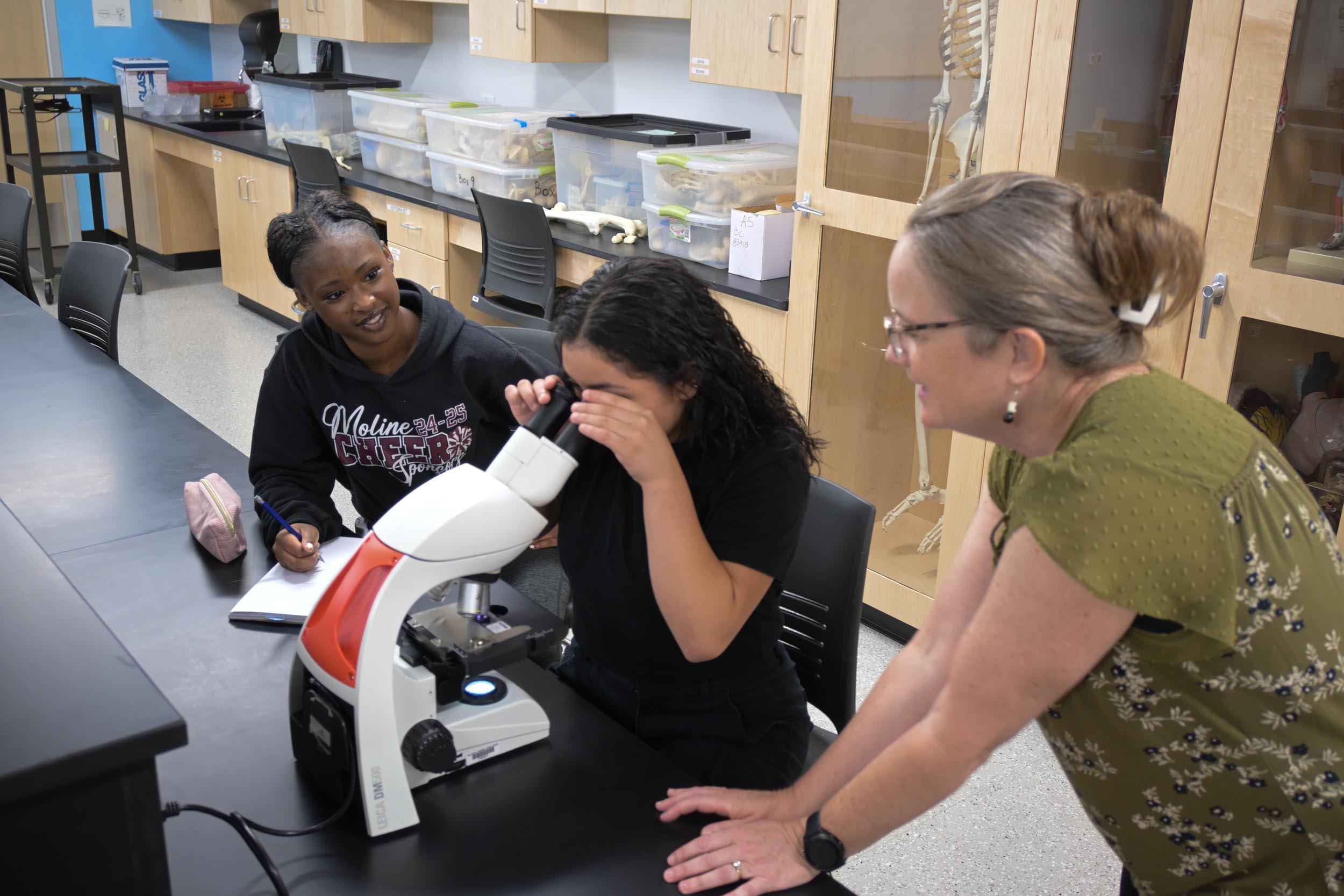 Students observing through a microscope.