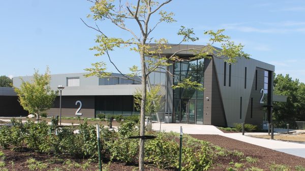 Exterior of two-story academic building with landscaping and sidewalks