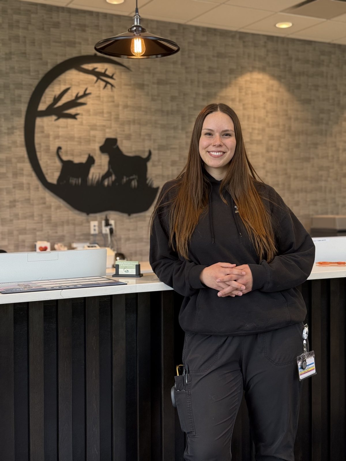 Turning passion into practice: a vet tech success story Smiling woman at reception desk.