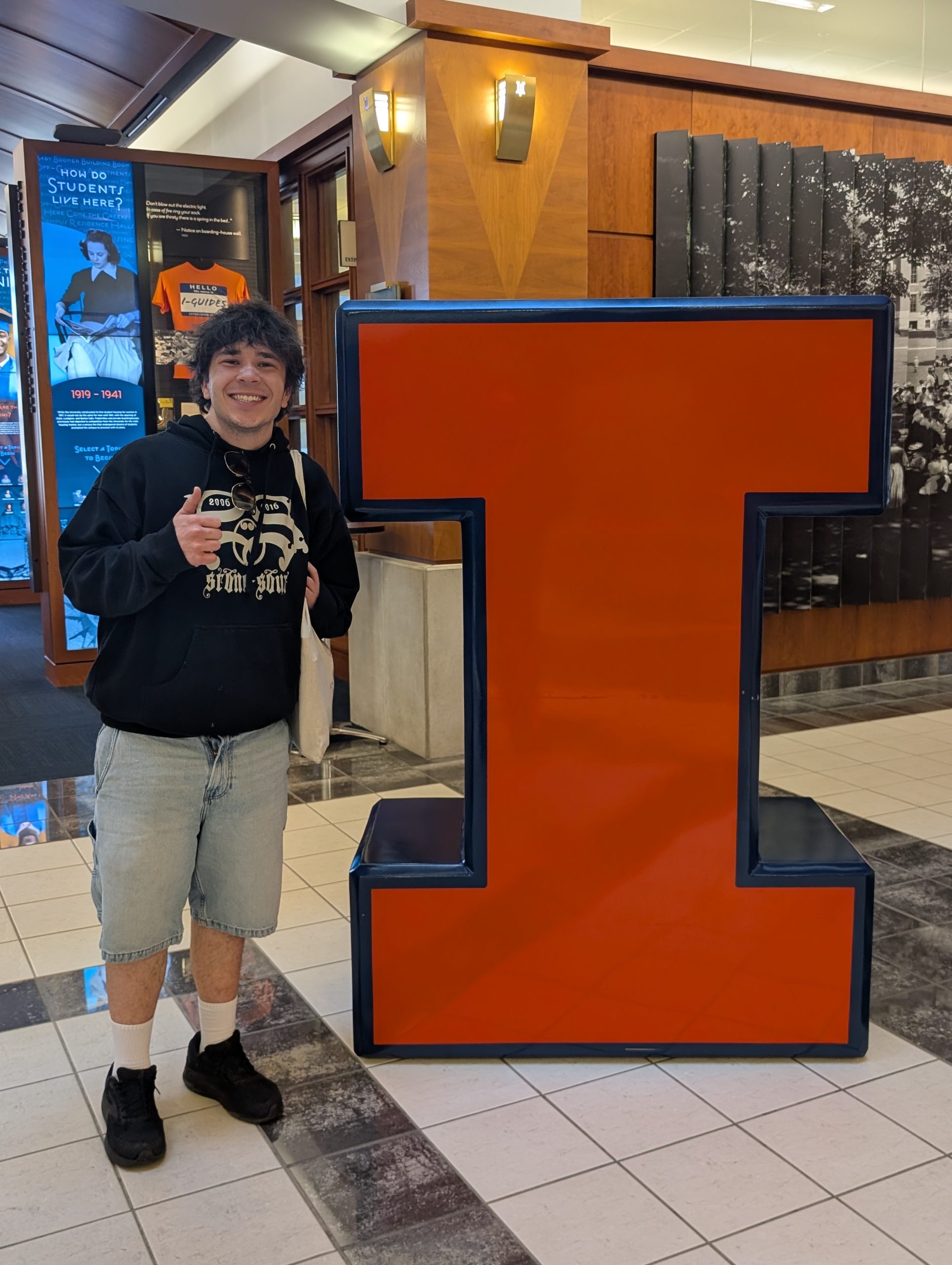 Student posing with large letter i