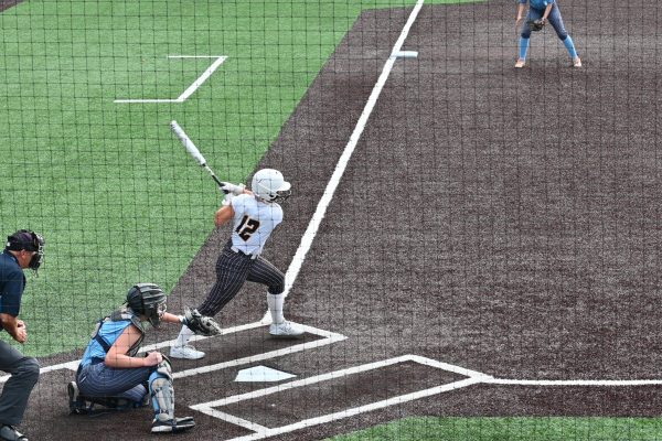 Player hitting softball at home plate