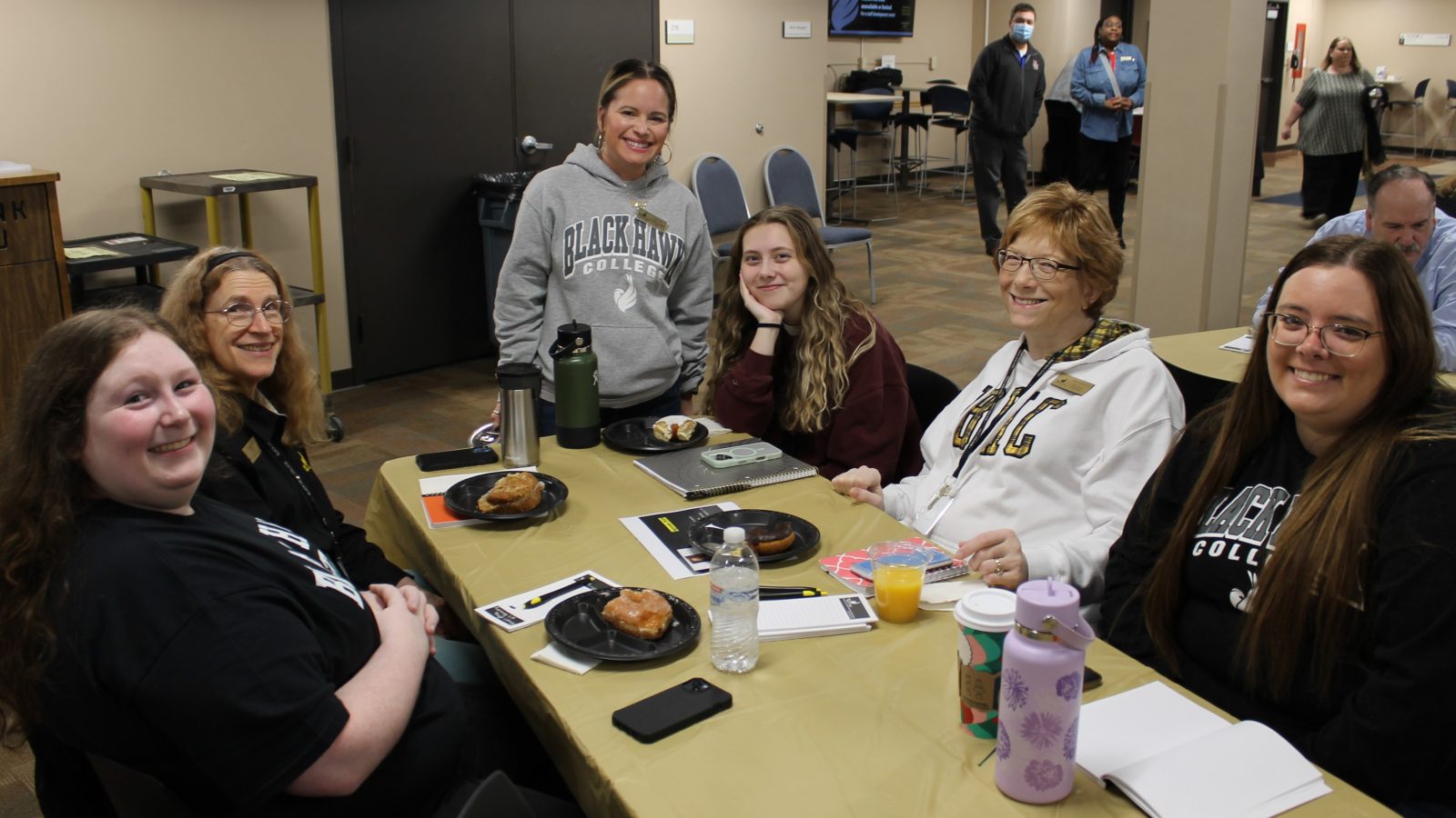 6 people at a table and smiling at the camera.