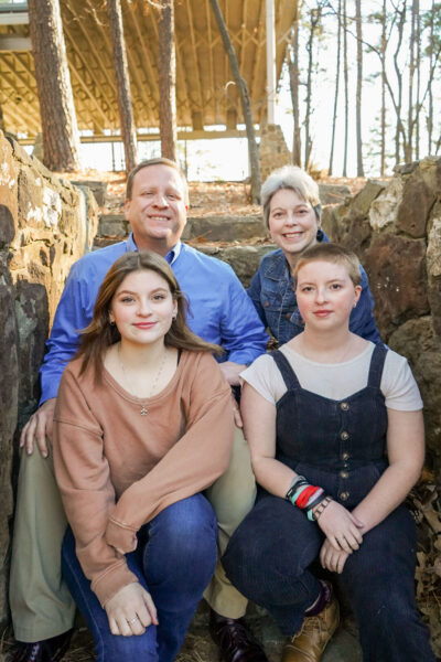 President jeremy thomas and family pose sitting in a barn.