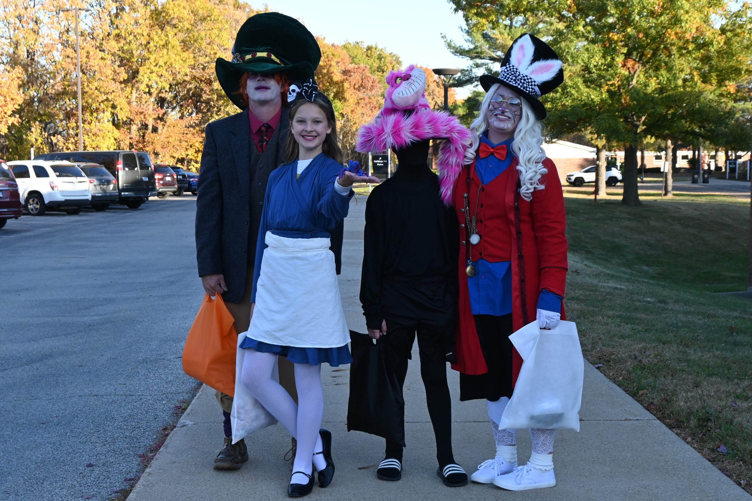 four kids people dressed as Alice in Wonderland characters.