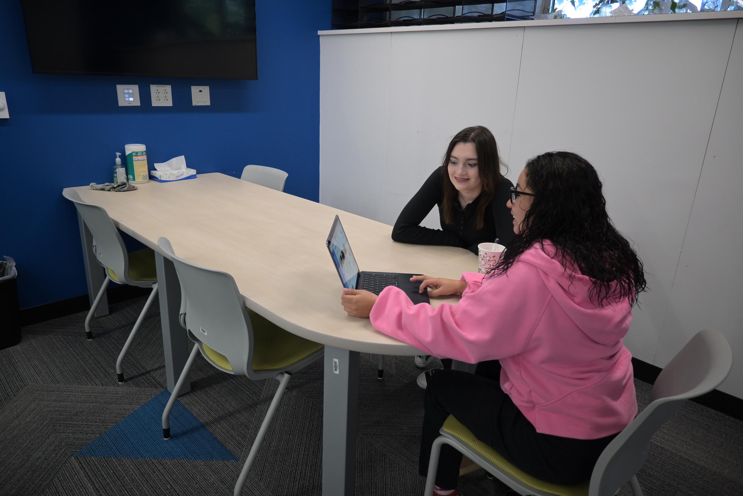 Two students collaborating at a table.