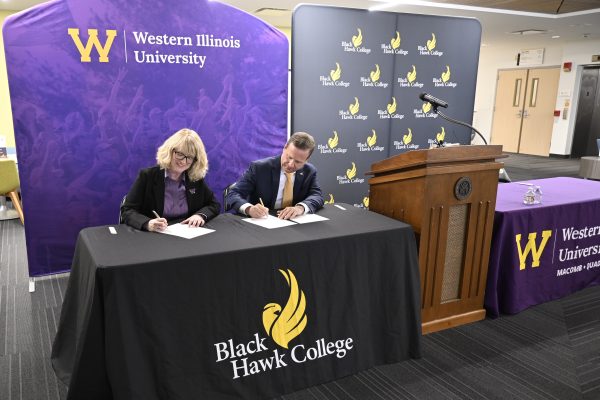 Dr. Kristi mindrup and dr. Jeremy thomas sign the articulation agreement during a press conference.