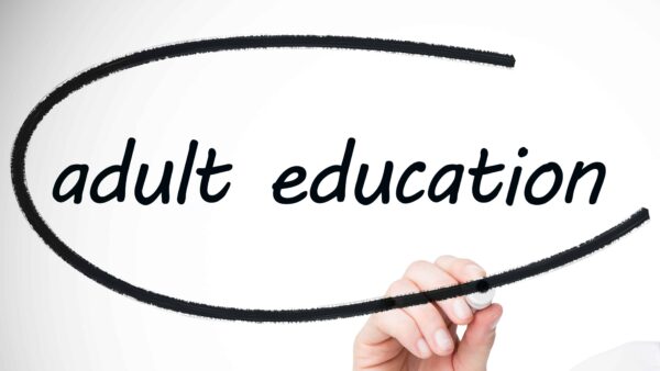 Hand writing adult education on whiteboard