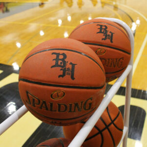 2 basketballs in a black hawk gymnasium