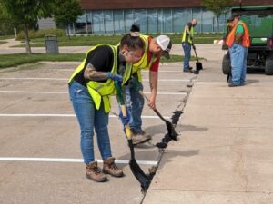 Congrats to spring 2024 highway construction grads Highway construction students filling potholes in parking lot on campus