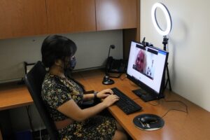 Woman sitting at a desk using a computer to try out the interview equipment at careers services