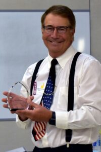 Smiling man holding an award