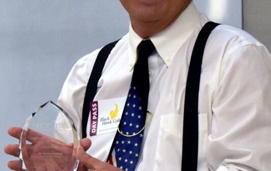 smiling man holding an award