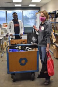 Man and woman with cart filled with bags of food