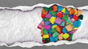 Profile of head made from colorful torn pieces of paper with crumbled paper background