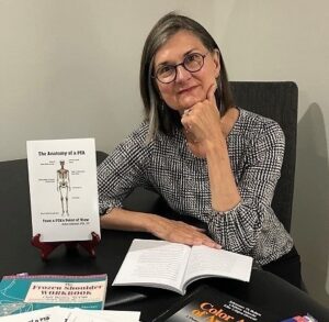 Woman sitting at table covered with books