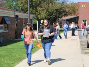 A group of people walking on a sidewalk