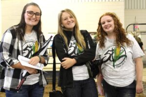 Three smiling female students wearing east campus 50th t-shirts