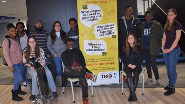 Trio students gathered around a banner